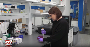 A still shot taken from WKOW television segment of Dr. Bryn Webb at the lab bench.