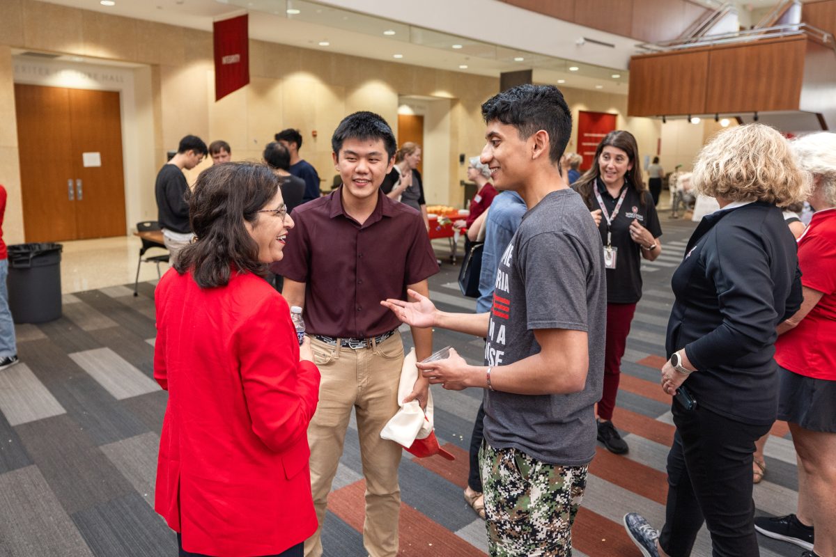 Zhongmou Jin (middle) and Sam (Samanyu) Ambedwadkar (right) of the Lang Lab and Murtaza Lab, respectively, converse with Dean Nita Ahuja.