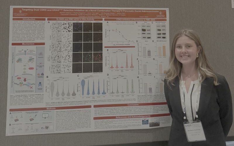 Michela Cadarso standing next to her American Association for Cancer Conference poster