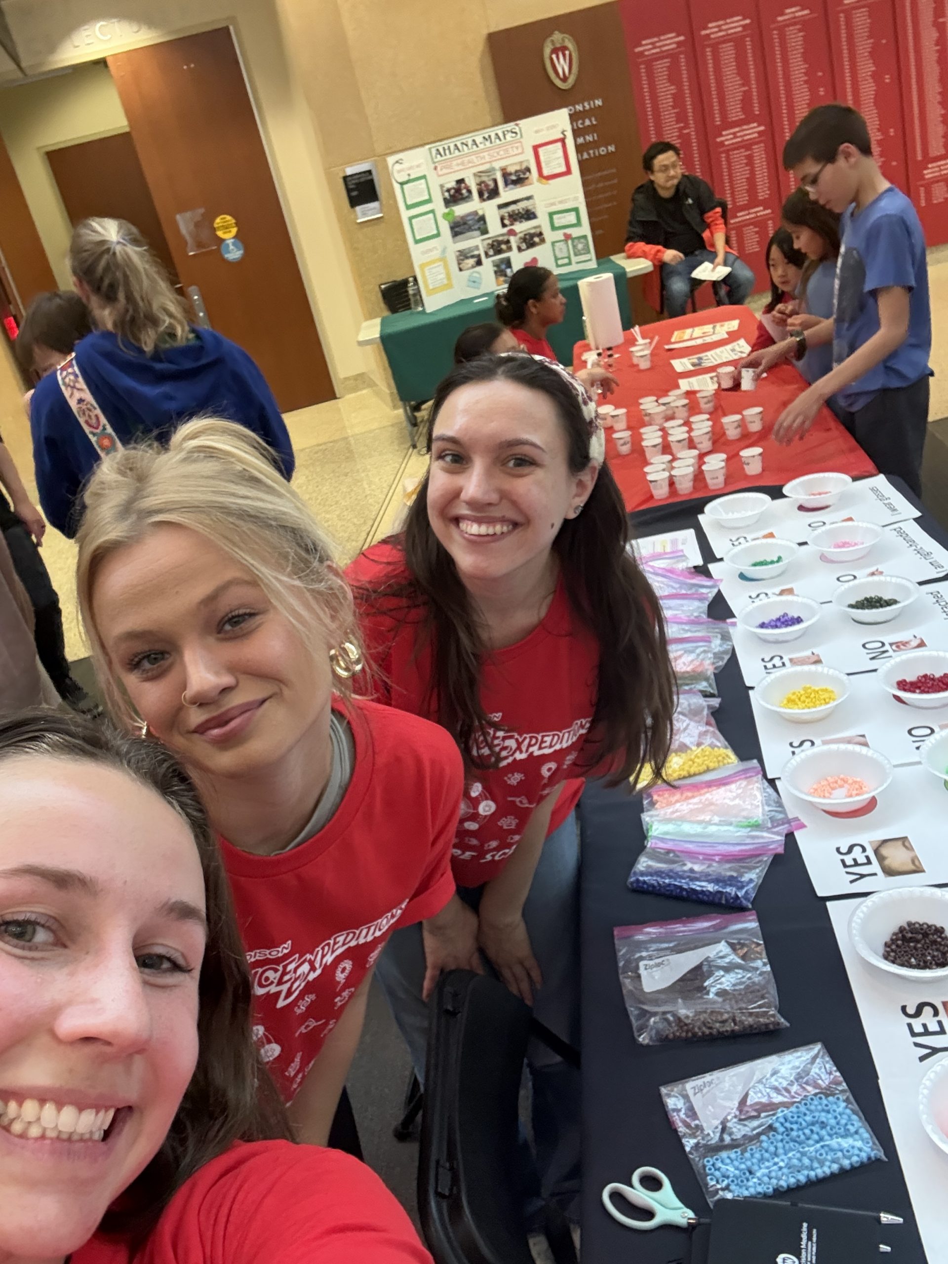 Kira Hills, Rachel Lichte, and Megan Huss staff the activity table. 
